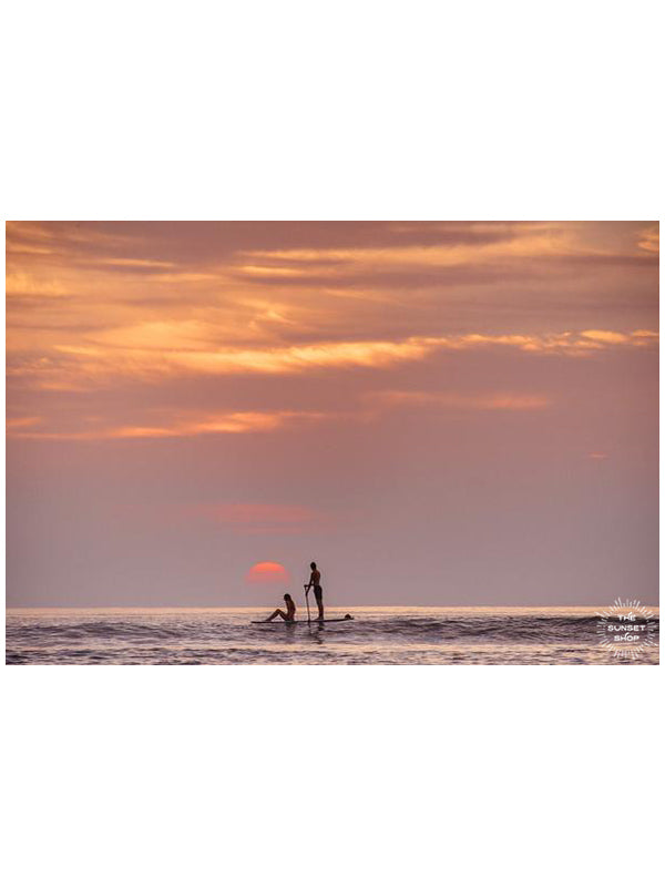 Let&#39;s go somewhere the sun kisses the ocean. Stand up paddle boarder couple watching sunset from the Pacific Ocean in Tamarindo Costa Rica. Photographed by Kristen M. Brown, Samba to the Sea for The Sunset Shop.