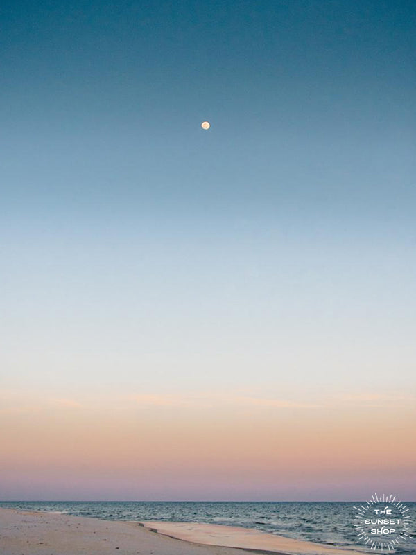 Full moon rising during a pastel sunrise at the beach over the Gulf Coast in Gulf Shores, Alabama. Photographed by Kristen M. Brown, Samba to the Sea for The Sunset Shop.