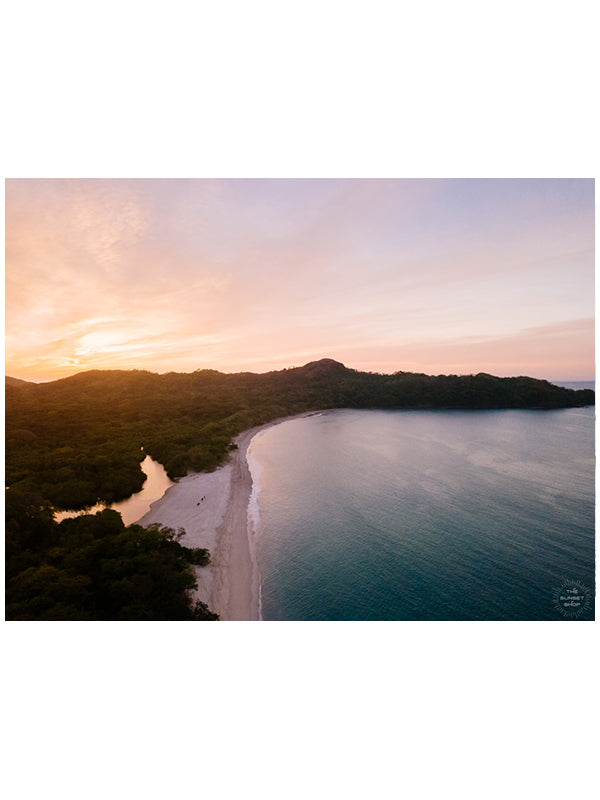 "New Year Magic" aerial sunset print by Samba to the Sea at The Sunset Shop. Image is an aerial photo of sunset over the beach in Playa Conchal, Costa Rica.