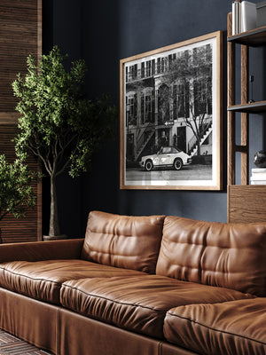 Vintage Porsche 911 parked in Savannah, GA black and white wall art in man cave library with dark walls and leather couch. Welcome back to your Savannah daydream, all from the comfort of your home...wherever home may be with this B&W photo print "One Way 911". 