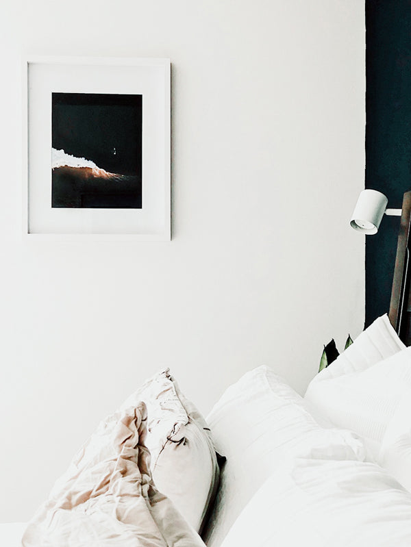 Surf Shack vibes in a midcentury modern home. Aerial surfer print by Samba to the Sea at The Sunset Shop. Image is an aerial photo of surfer paddling out to surf in Tamarindo, Costa Rica.