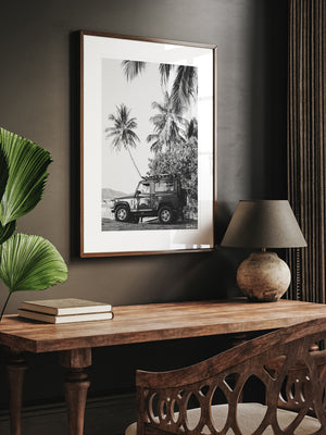 Black and white photography vintage Land Rover wall art for home office. Nothing quite comes close to evoking that feeling that a tropical beach adventure is about to happen than a Land Rover Defender. So what are you waiting for? Hop on in and adventure away to find your tropical beach paradise! "Paradise Found Rover" black and white Land Rover Defender beach and palm trees photo print by Kristen M. Brown of Samba to the Sea for The Sunset Shop.