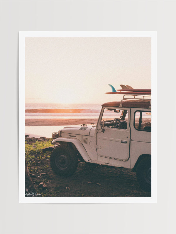 "Seek and You Will Find" photo print of vintage Toyota FJ40 Land Cruiser racked up with surfboards parked at the beach in Costa Rica as the waves peel and the sun kissing the horizon turns everything golden. Photographed by Costa Rica photographer Kristen M. Brown of Samba to the Sea for The Sunset Shop.