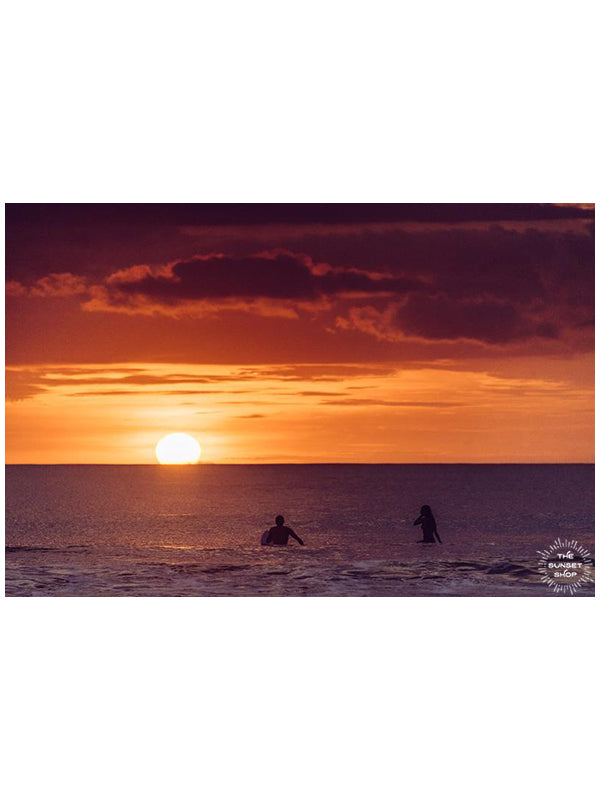 Surf Amor. Surfer couple watching sunset on their surfboards in Tamarindo Costa Rica. Photographed by Kristen M. Brown, Samba to the Sea for The Sunset Shop.