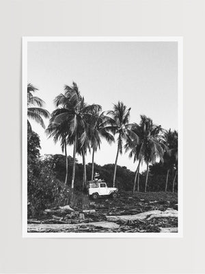  "Surf Bandida" black and white photo print of surfer girl checking the surf with her vintage Toyota FJ40 Land Cruiser racked up with surfboards among the palm trees in Costa Rica. Photographed by Costa Rica photographer Kristen M. Brown of Samba to the Sea for The Sunset Shop.