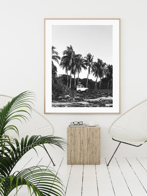 Tropical neutral living room with palms, Acapulco chair, and black and white photo print. "Surf Bandida" black and white photo print of surfer girl checking the surf with her vintage Toyota FJ40 Land Cruiser racked up with surfboards among the palm trees in Costa Rica. Photographed by Costa Rica photographer Kristen M. Brown of Samba to the Sea for The Sunset Shop.