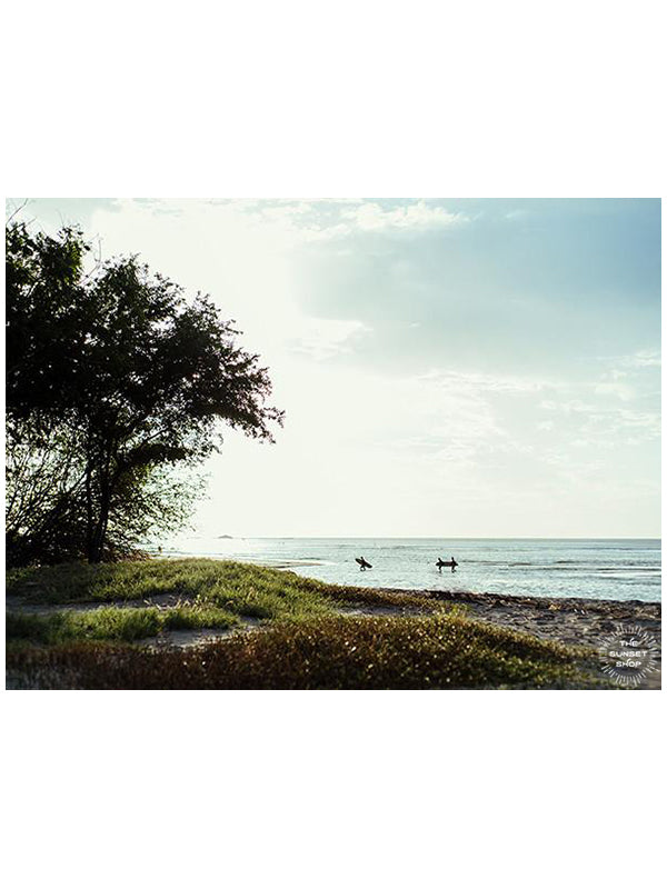 Surfers crossing the river in Tamarindo, Costa Rica. Surfer Crossing print by Samba to the Sea at The Sunset Shop.