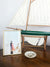 American flag hanging on the Tybee Island Lighthouse. Nautical home decor with model sailboat. "Sweet Liberty" available at The Sunset Shop by Kristen M. Brown of Samba to the Sea.