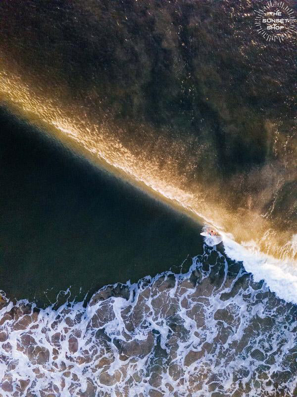 Aerial surfer print by Samba to the Sea at The Sunset Shop. Image is an aerial photo of surfer dropping in on a wave in Tamarindo, Costa Rica.