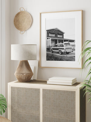 Vintage Jeep Wagoneer black and white wall art in tropical neutral room. Welcome back to that amazing family beach vacation, all from the comfort of your smart home...wherever that smart home may be with this B&W photo print "Wrightsville Wagoneer".  Photographed by Kristen M. Brown of Samba to the Sea for The Sunset Shop.