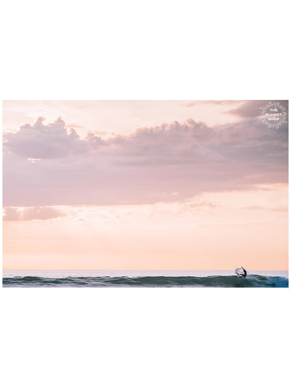 Surfer on a turquoise wave during a rosé sunset in Costa Rica. Yes Wave Rosé sunset surfer wave print by Samba to the Sea at The Sunset Shop. Image of a surfer doing a gorgeous snap on a turquoise wave during a beautiful sunset in Costa Rica. 